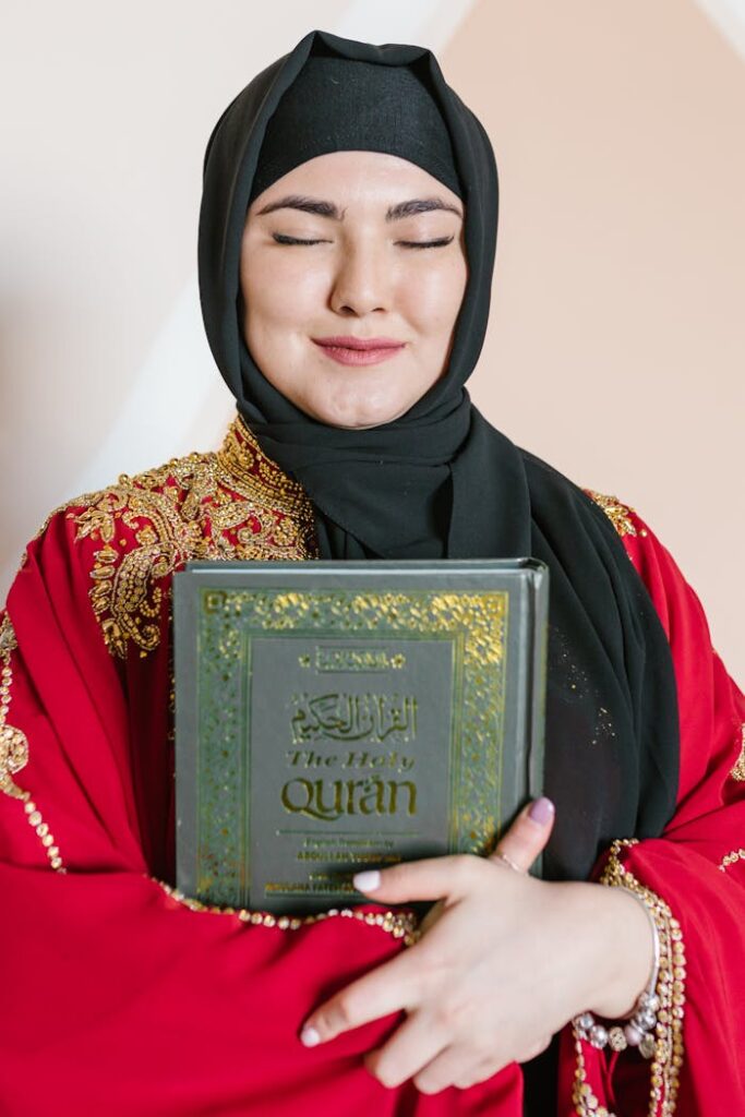 Woman in Black Hijab Holding A Holy Book